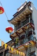 chinese building with lanterns and flags on lines across street, usa, california, san francisco