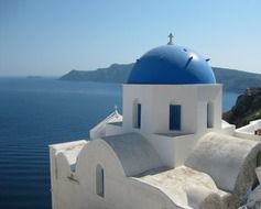 orthodox church building with blue dome at sea, greece