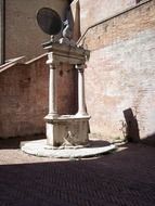 oldtime well with columns on street, italy, siena