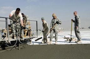 road construction, workers smoothing concrete