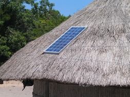 solar panel on straw roof of tribal hut