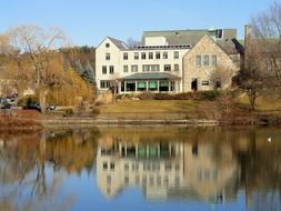 winchester public library building mirroring on calm water at fall, usa, massachusetts