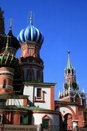 colorful domes of st basil’s cathedral and kremlin tower at sky, russia, moscow