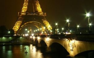 illuminated bridge across siene river at eiffel tower at night, france, paris