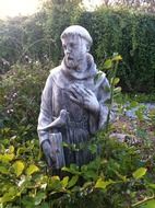 saint francis with bird, stone statue in garden