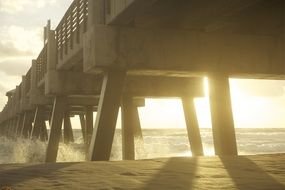 waves splashing on breakwater under wooden pier