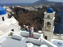 couple kissing on roof at church in beautiful landscape, greece, santorini