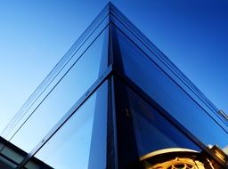 exterior corner of blue glass facade at sky