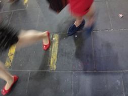 woman’s legs walking away on tile pavement