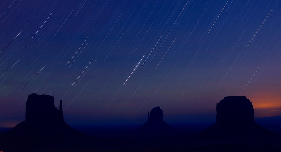 startrails at night sky above monument valley, usa, arizona