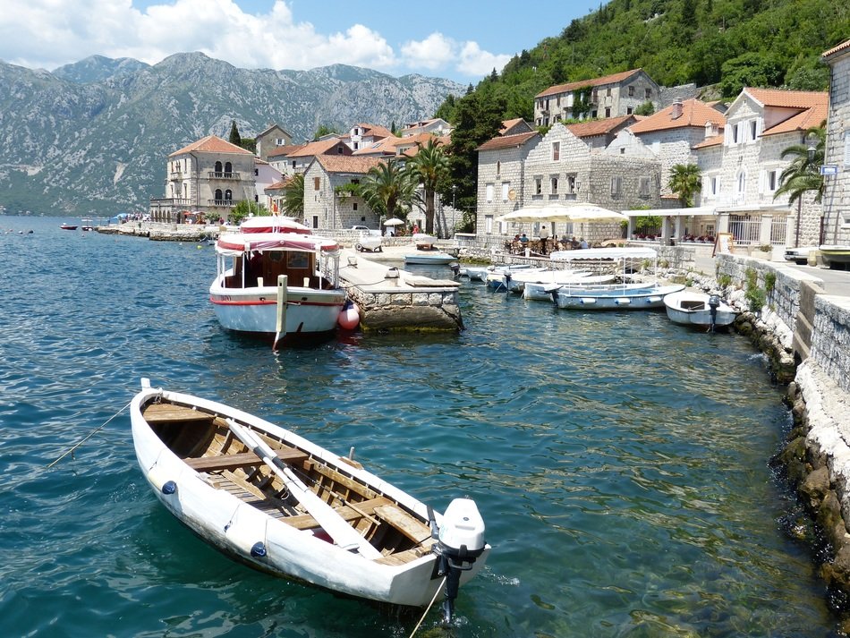 boats on water at beautiful villas on mountain side, montenegro, perast