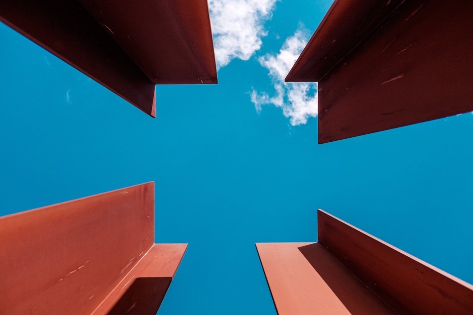 four red metal beams at blue sky