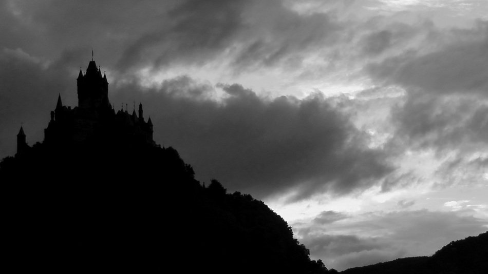 castle on top of mountain, silhouette at clouds