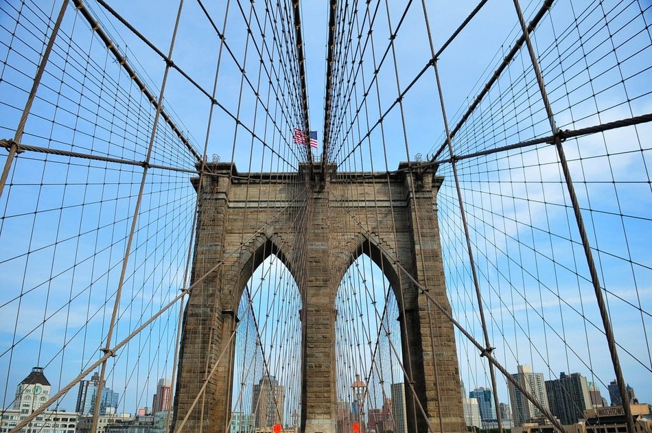 view of new york city througt brooklyn bridge constructions, usa