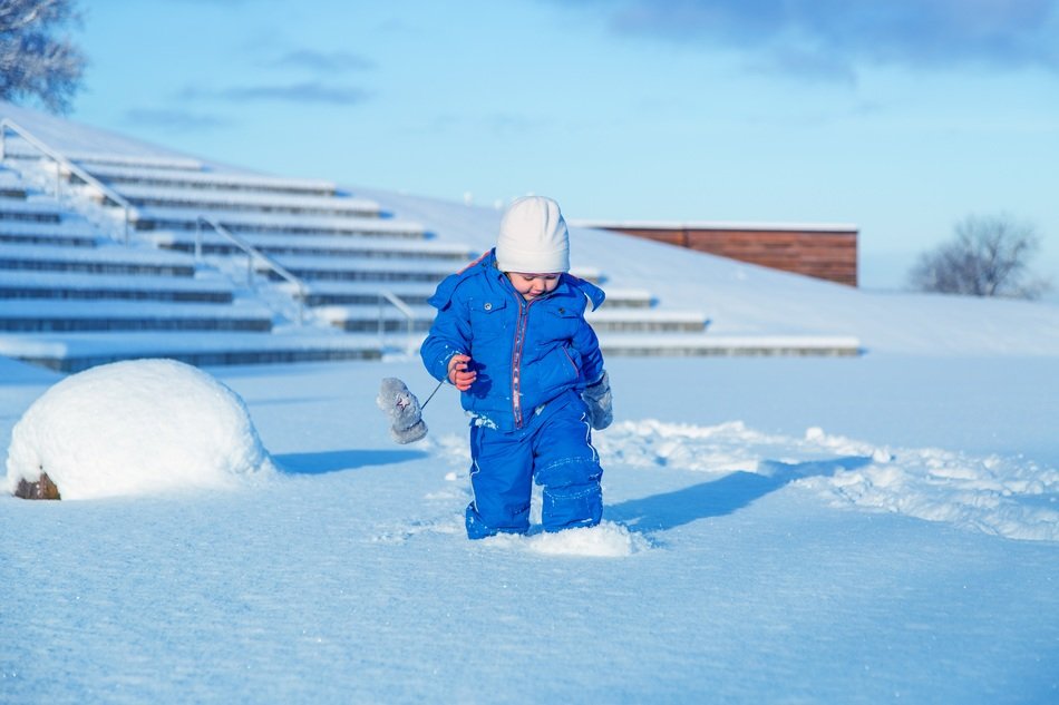 Child in blue clothes in the snow