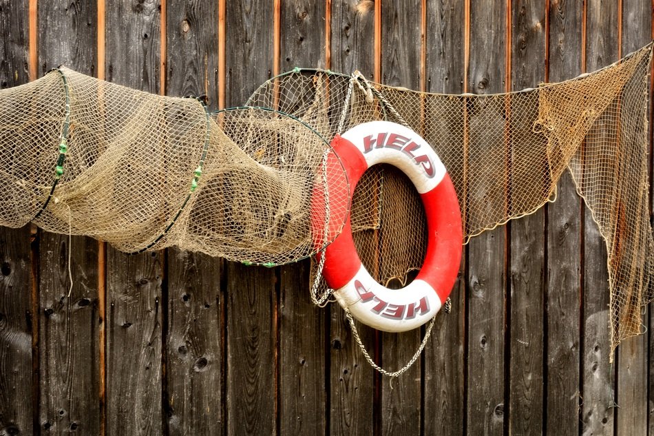 fishing net and lifebelt on a wooden wall