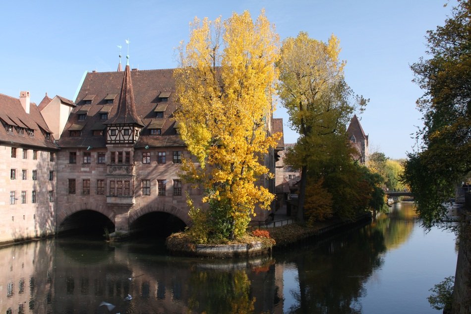 autumn landscape with medieval hospital building at water, germany, nuremberg