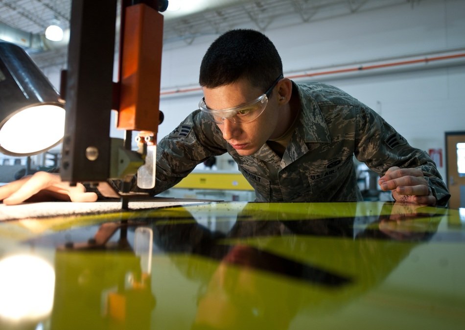 construction worker cutting sheet with band saw