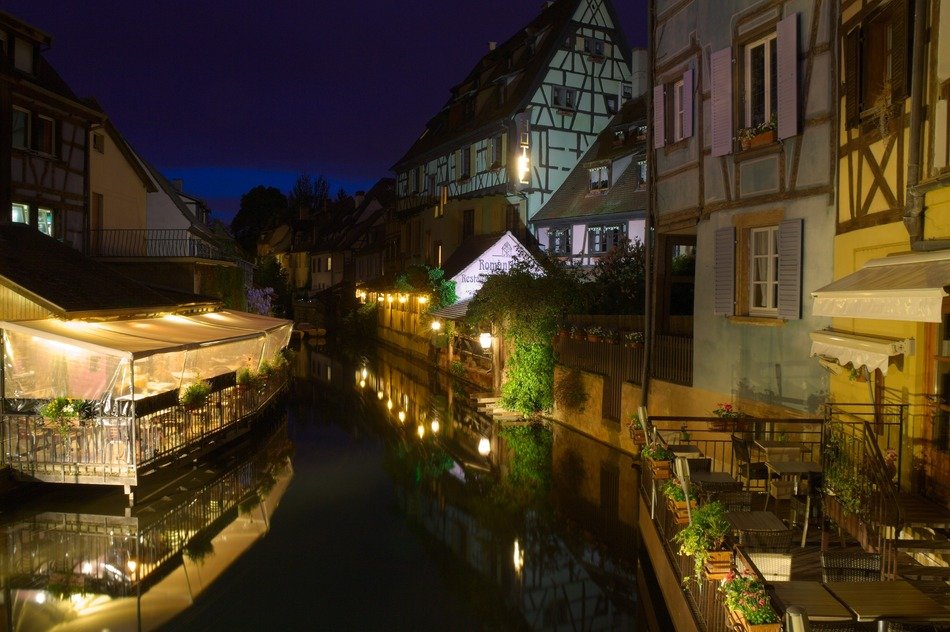 beautiful old buildings with waterside terraces at night, france, alsace, colmar