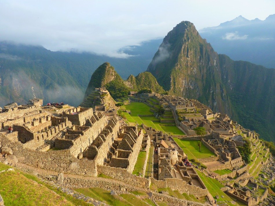 machu picchu, inca town ruins on green mountain under clouds, peru