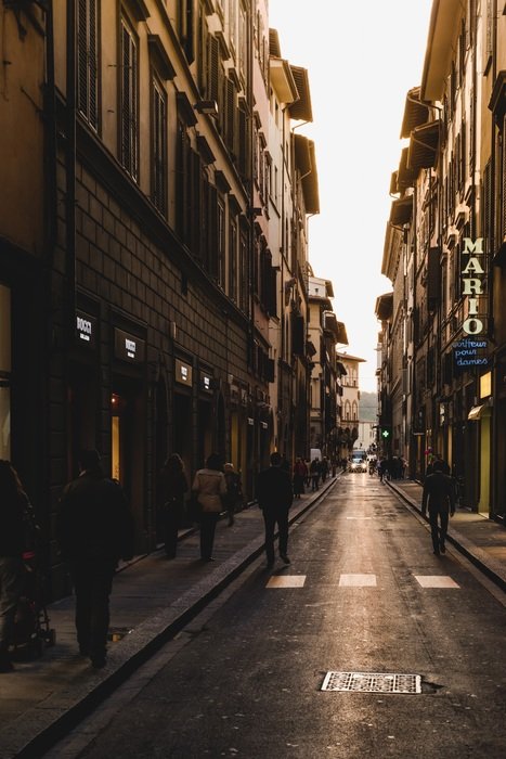 people on narrow street in city at dusk