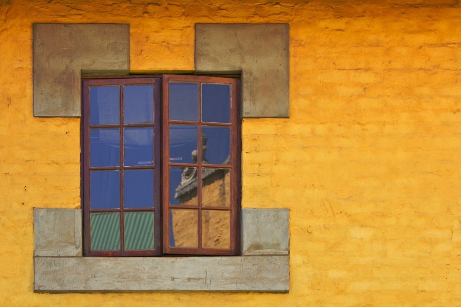 reflection in a window on a yellow facade