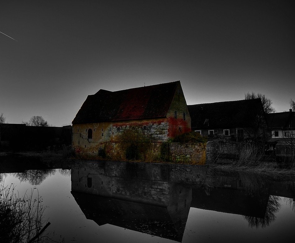 old buildings at water in darkness
