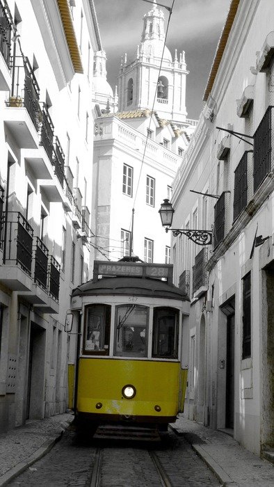 yellow tram on narrow street in old town, portugal, lisbon