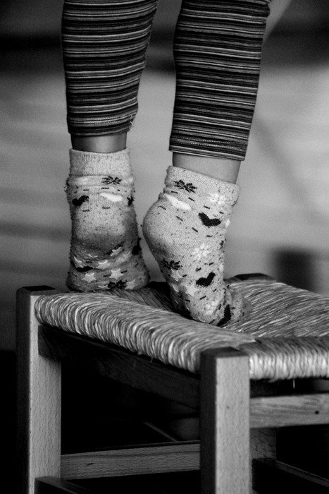 childâs feet in socks on chair