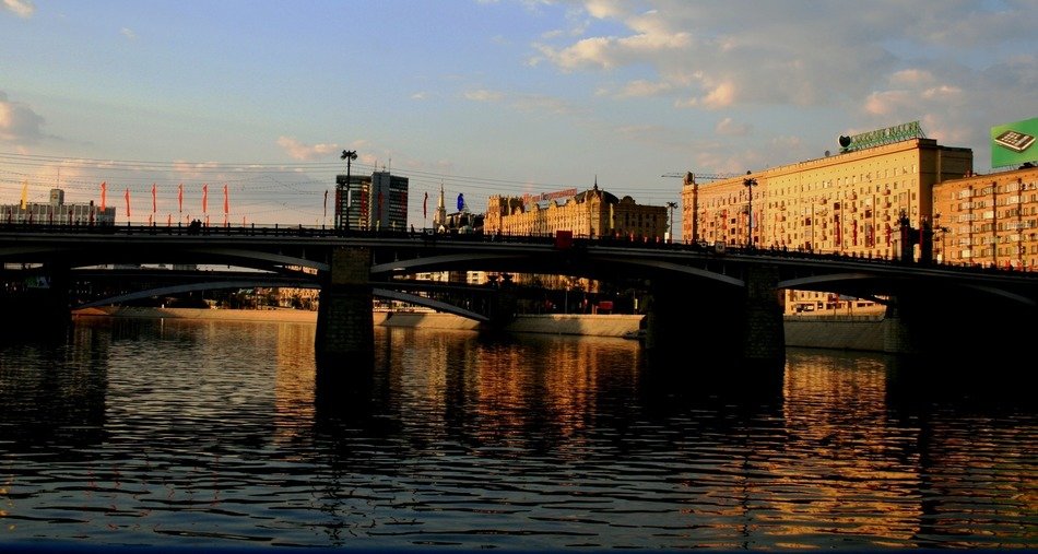 old bridge across river in city at evening