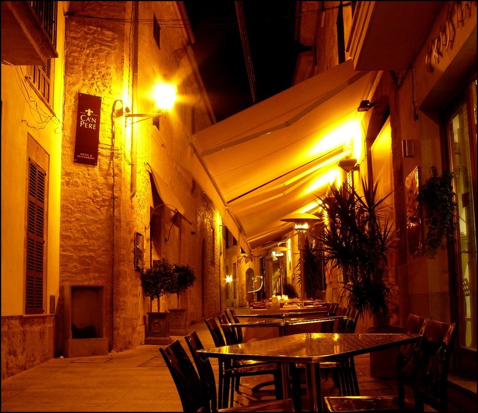 open air restaurant on narrow street of old town at night