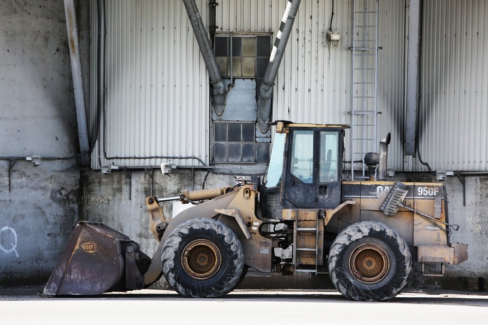 excavator near factory wall