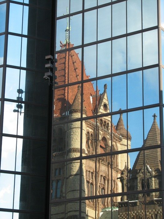reflection of medieval castle on modern glass facade