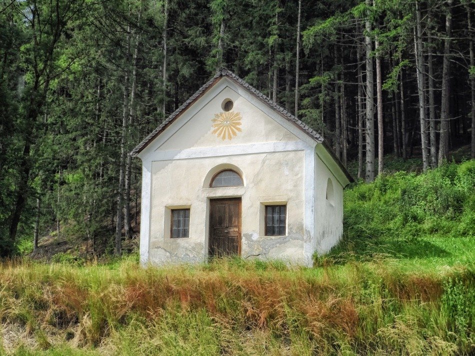 small white chapel at summer forest, austria