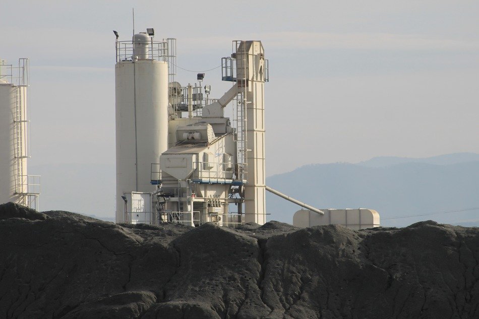 Asphalt plant buildings behind dump