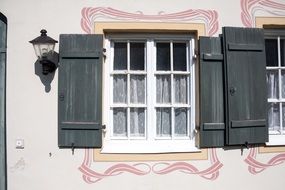 art nouveau windows with shutters on a building wall