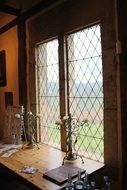 candelabras on desk at grated window