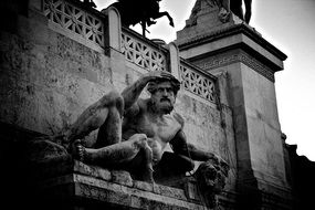 laying man with lion head in arm, ancient stone sculpture, italy, rome