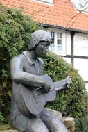 stone statue of musician with guitar