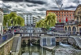 people at dam on channel in city, uk, england, london