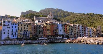 row of colorful old houses on coast at mountain, italy, liguria, porto venere