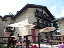 people at table under umbrella in beer garden, italy, palanfre