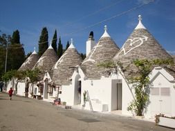trullo houses in row on street, italy, alberobello