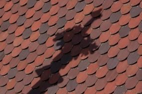 Shadow of a cross on a tiled roof