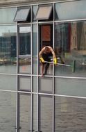 window cleaner, man with mop on glass facade