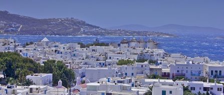 white village houses at blue sea, greece, mykonos