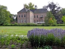landscape of old stone house in summer garden in netherlands