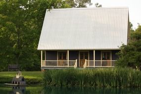 cottage among trees at pond