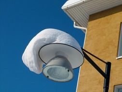 snow capped streetlight lamp at sky