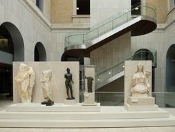 ancient sculptures in interior of modern museum